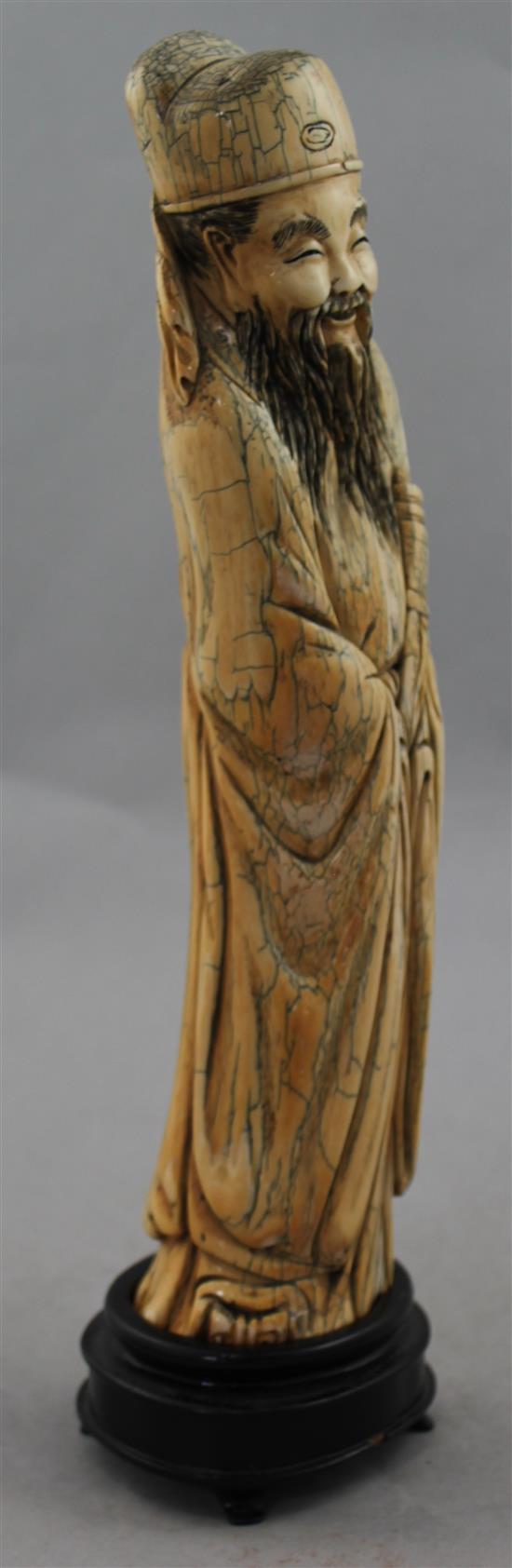 A Chinese mammoth ivory carving of an immortal, in Ming style, 20th century, 30cm, wood stand